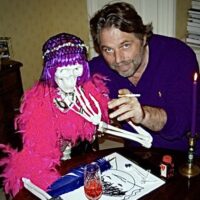 A man in his 40s or 50s is pictured holding a cigarette with his arm around a life size model skeleton that is wearing a feather boa and a wig. The man is Michel van Rijn.
